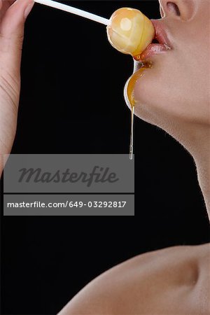 Femme tenant lollipop miel sur ses lèvres