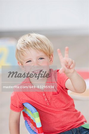 young boy holding up three fingers