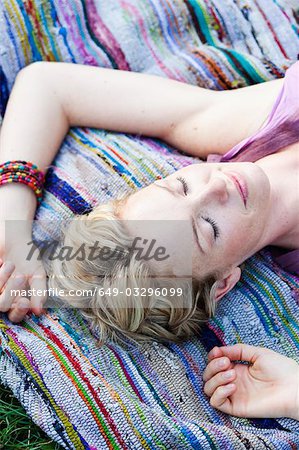 woman lying on blanket eyes closed