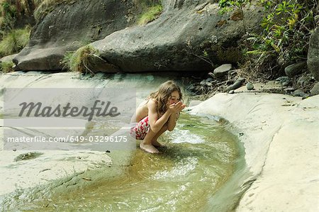 Mädchen Trinkwasser aus stream