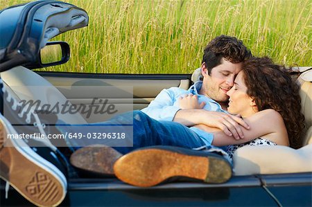 Couple pose dans une décapotable