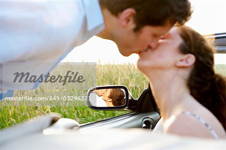 Couple kissing in a convertible