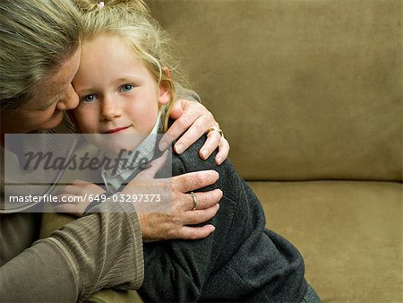 A young girl being hugged by her mum
