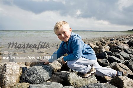 Boy walking over stones