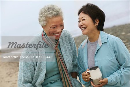 Two female friends talking on beach