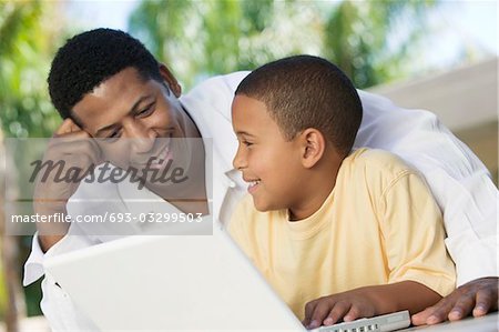 Père et fils assis sur le patio Using Laptop, gros plan