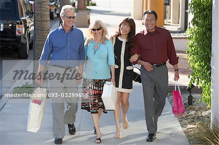 Couples walking arm in arm, holding hands outdoors on Shopping Trip