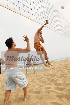 Man in Mid-air Going for Volleyball on beach