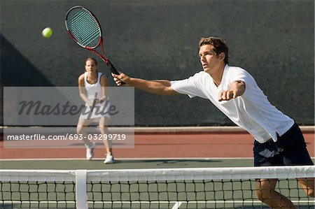 Doubles Player stretching, Hitting tennis ball with forehand near net