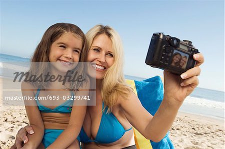 Girl and mother photographing themselves on beach