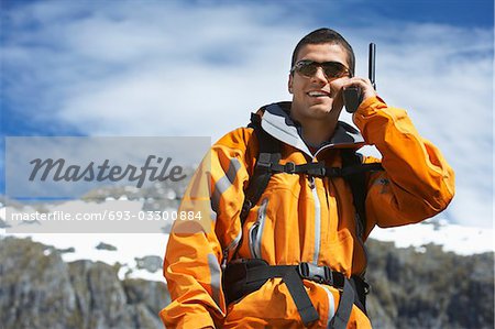Homme utilisant talkie-parler sur le sommet de la montagne