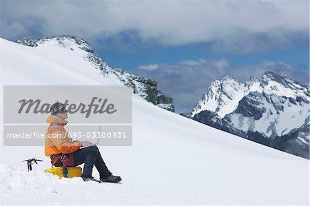 Wanderer mit Laptop auf verschneite Berggipfel