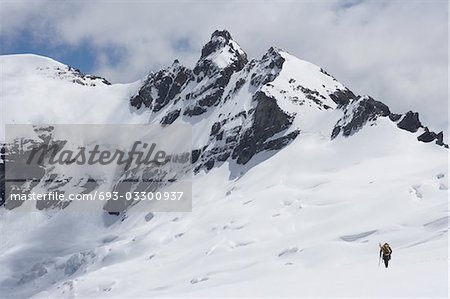 Wanderer, die Leitung für fernen Gipfel im Schnee, Rückansicht
