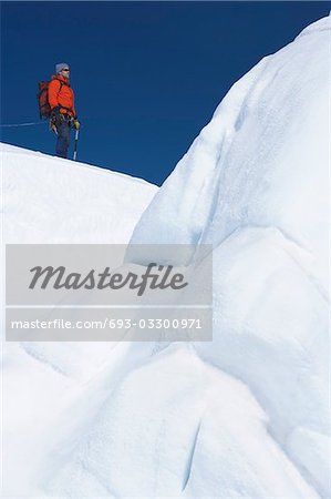 Mountain climber hiking past ice formation