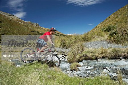 Cyclist riding through rocky field