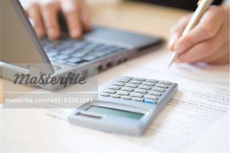 Femme avec ordinateur portable et une calculatrice, gros plan