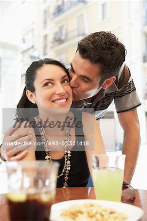 Jeune couple au café trottoir, baisers phrygienne, portrait