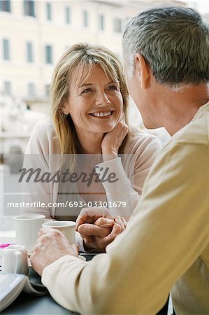 Middle-aged couple sitting at outdoor cafe in Rome, close up