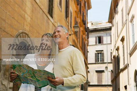 Couple on street with map in Rome, Italy, low angle view