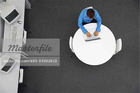 Man Using Laptop in computer room, overhead view