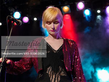 Jeune femme chantant en Concert sur scène, vue de face, vue de l'angle faible
