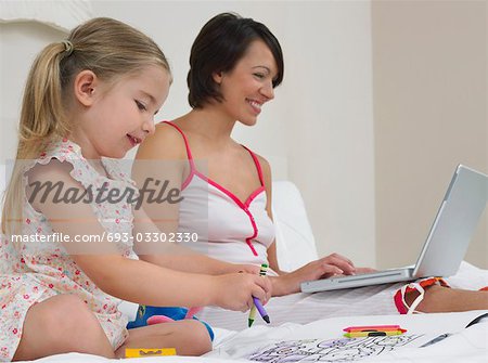 Dessin de mère en fille et utilisant un ordinateur portable sur le lit