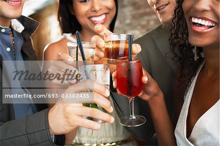 Friends toasting  in bar, close up on glasses