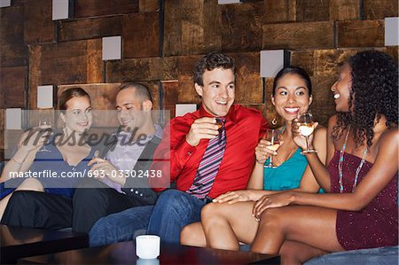 Friends talking and drinking while sitting in bar