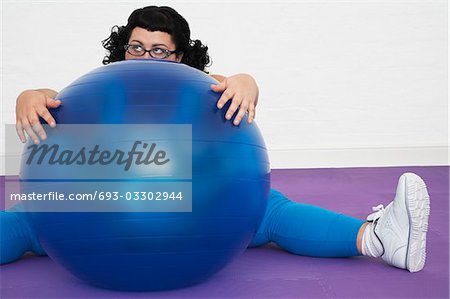 Femme obèse sans inspiration assis derrière ballon d'exercice