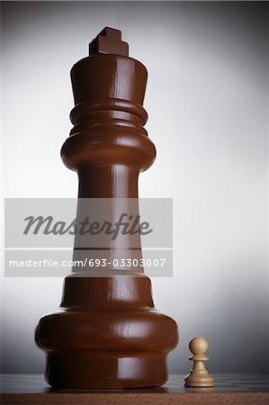 Two chess pieces, large king and small pawn