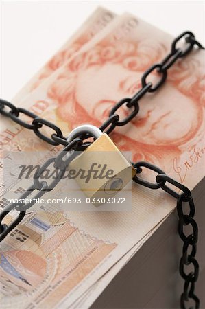 Stack of fifty pound notes secured by padlock and chain