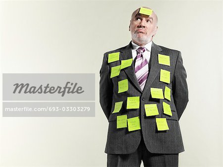 Businessman covered with sticky notes