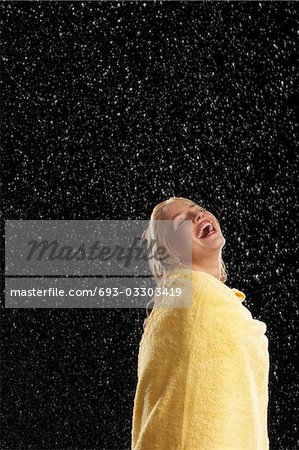 Femme riante serviette debout sous la pluie