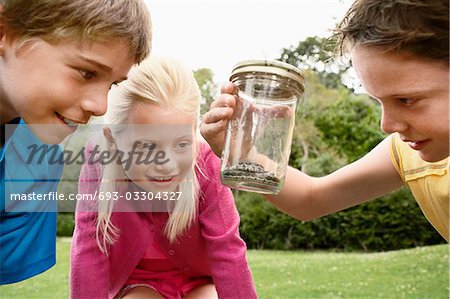 Enfants regardant le serpent dans le récipient