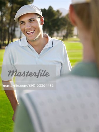 Jeunes golfeurs sur le parcours, mettre l'accent sur l'homme souriant