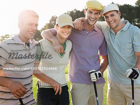Groupe de jeunes golfeurs posant sur cour, portrait