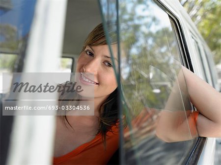 Jeune femme regardant par la fenêtre van, demi-longueur