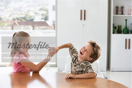 Junge Mädchen und junge kämpfen am Tisch zu Hause