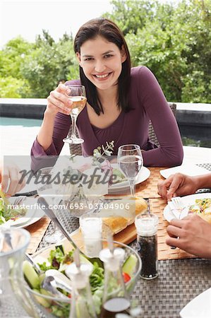 Jeune femme à boire vin lors d'une réception en plein air