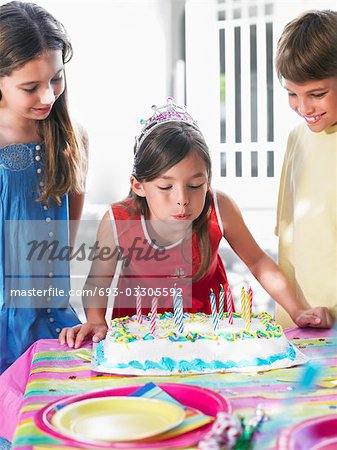 Girl (8-12) blowing out birthday candles