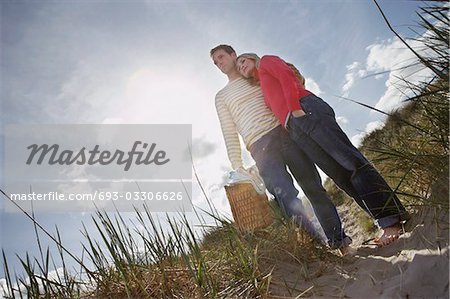 Couple embrassant sur la dune de sable