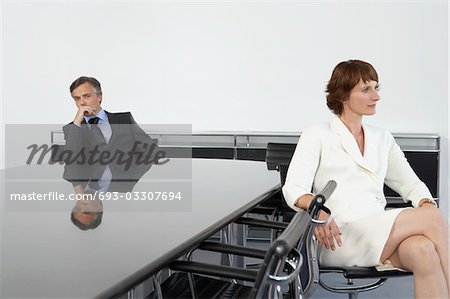 Business woman with back to business man at conference table
