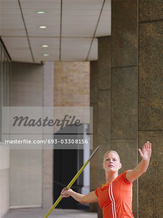 Woman throwing javelin outside building