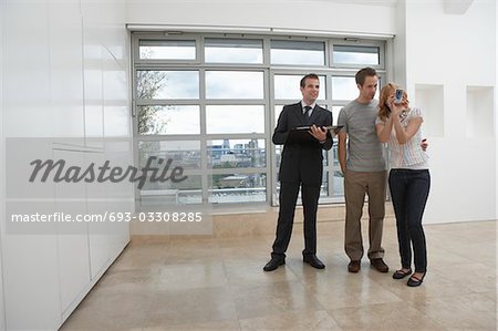 Real estate agent showing couple new apartment