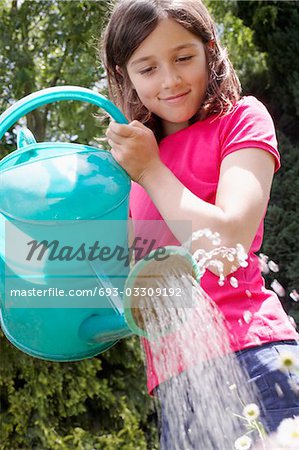 Girl (7-9) watering garden