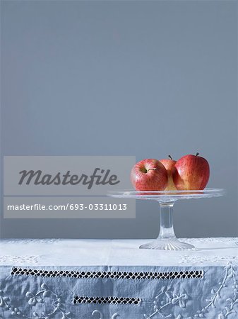 Trois pommes sur le plateau de fruits sur table