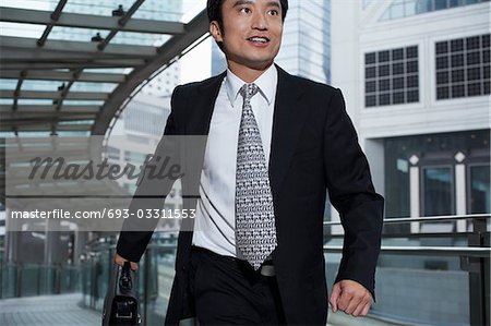 China, Hong Kong, business man running through footbridge