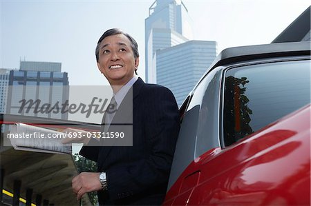 Business man jumping with blank sign outdoors
