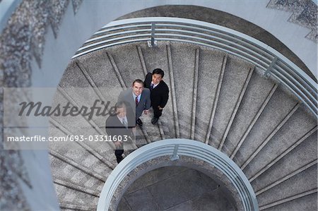 Trois des associés d'affaires permanent sur l'escalier en colimaçon, portrait