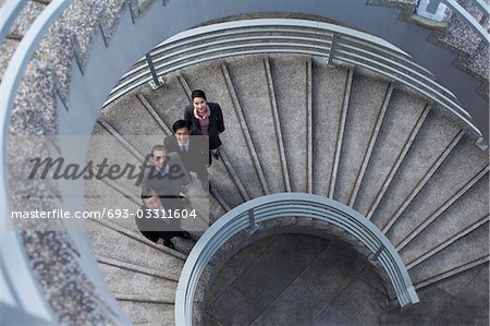 Quatre associés d'affaires permanent sur l'escalier en colimaçon, portrait